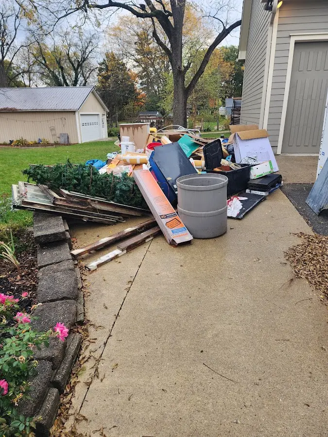 Dumpster being loaded with debris for 12 Yard Dumpster Rental in Norwood